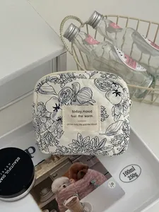Pochette en coton matelassé à motif floral bleu avec fermeture éclair pratique