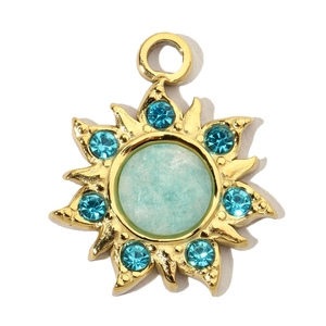 Macro view of gold sun pendant with light blue stone and teal zircon accents
