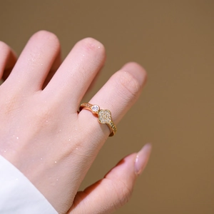 Eleganter goldener Kleeblatt-Ring mit Zirkonia-Steinen an der Hand eines weiblichen Models