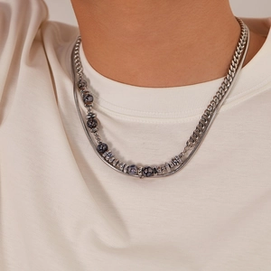 Detail of layered silver stainless steel necklace with grey beads on male model neck