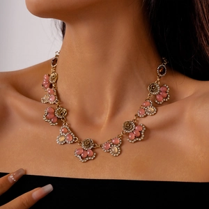 Close-up of vintage flower necklace with pink and amber stones on model neck