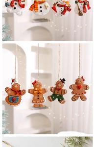Close-up of gingerbread man and snowman ornaments hanging on a Christmas tree