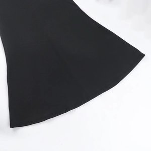 Détail de l'ourlet en tissu noir lisse et des coutures professionnelles de la robe