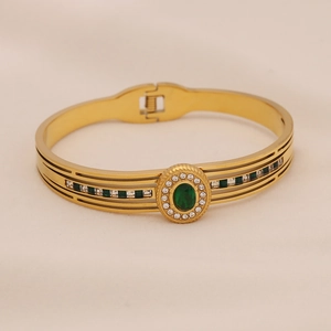 Détail du bracelet jon jonc doré vintage serti de pierre émeraude et zircons blancs