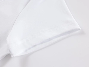 Detail view of reinforced double-needle stitching on white ribbed knit t-shirt cuffs
