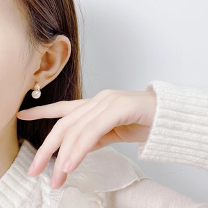 Elegant snowman-style double pearl earrings with gold metal links shown on model