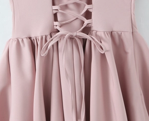 Detailansicht eines rosa Kleides mit Schnürung am Rücken und Taillen-Schleifendetail