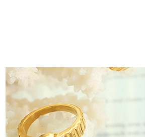 Close-up of gold-plated layered necklace ring pendant with coin-edge gear texture