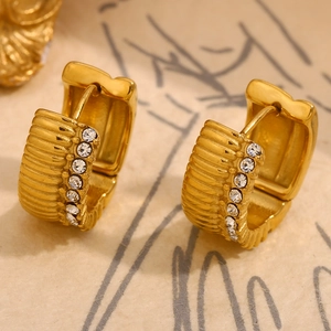 Macro detail of 18K gold plated textured hoop earrings with sparkling zircon stones
