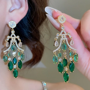 Detailed view of emerald zircon tassel earrings with marquise-cut green stones in gold