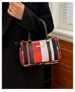 Gros plan du sac à main à rayures multicolores avec anses en similicuir marron et logo doré
