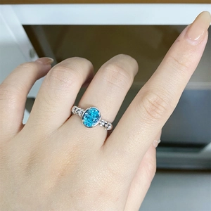 Close-up of S925 silver ring featuring neon blue Paraiba stone on finger