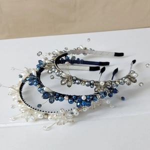 Detailed view of handcrafted crystal and pearl beaded headbands in blue and white