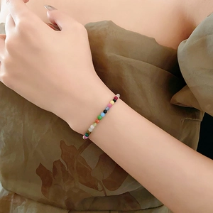 Close-up of a colorful beaded bracelet on a woman wrist with vibrant round mini beads