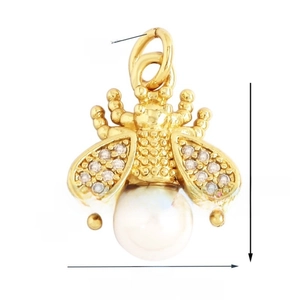 Detailed macro view of gold bee pendant with white pearl belly and zircon wings
