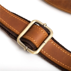 Détail de la bandoulière réglable en cuir marron avec boucle métallique de sac bandoulière