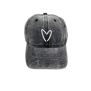 Close-up of heart embroidery on vintage grey washed denim baseball cap with curved brim
