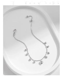 Close-up of silver beaded bracelet with polished heart pendants and zircon accents