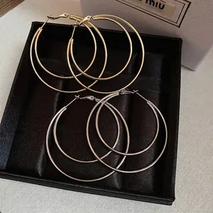 Double-layered concentric round metal hoop earrings set in polished gold and silver finishes