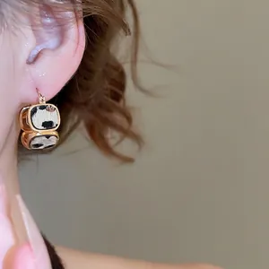 Orecchini quadrati placcati in oro 18 carati con stampa leopardata indossati da donna