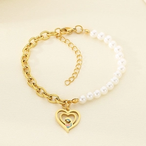Detail of gold titanium steel bracelet with pearls and mother-child heart pendant