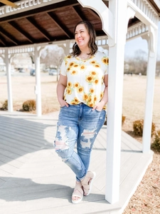 Photo de plein air d'un jean skinny bleu clair avec déchirures et t-shirt à tournesols