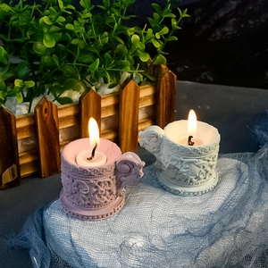 Primer plano de portavelas vintage con relieve floral y asa en lavanda y blanco