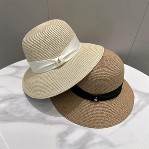 Detailed view of woven straw sun hats featuring elegant bow ribbons and metal buckles