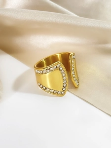 Nahaufnahme eines vergoldeten 18K Rings mit Zirkonia auf beigem Seidenstoff
