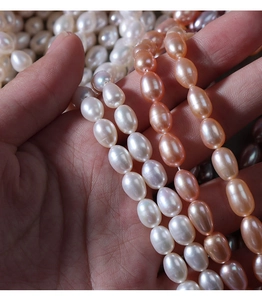 Macro detail of 5-6mm natural freshwater rice pearls in white and pink-orange colors