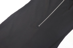 Close-up of a silver metal zipper on black high-stretch fabric of a slim fit jumpsuit