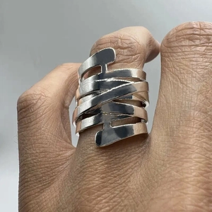 Dettaglio macro di un anello a fascia d'argento multistrato intrecciato geometrico