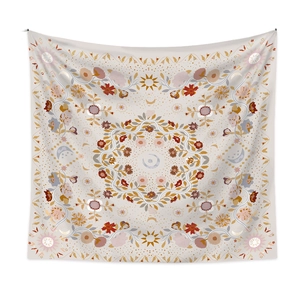 Detail of bohemian mandala tapestry featuring sun, moon and floral patterns on beige fabric