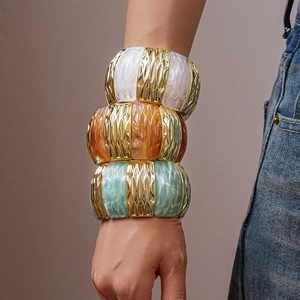 Macro detail of elastic resin bracelets with gold metal inserts and wave texture