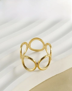 Detail of hollow geometric gold stainless steel ring on elegant display stand