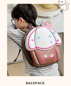Detailed back view of a 3D cupcake-shaped toddler backpack with strawberry detail on a boy