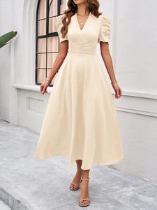 Detail view of beige V-neck maxi dress featuring elegant puff sleeves and pleated waistline