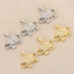 Detailed view of six elephant charms in polished gold and silver finishes on fabric