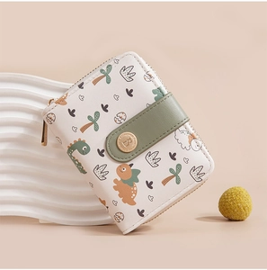 Close-up of white women's short wallet with cute cartoon dinosaur print and green strap