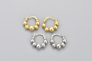 Macro shot of silver and gold beaded hoop earrings with S925 hallmark engraving