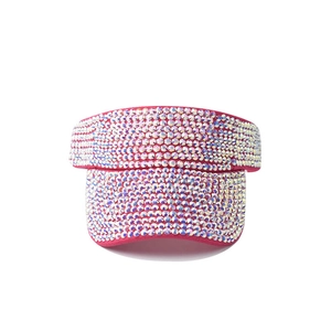 Macro detail of sparkling rhinestones on the brim of a pink sun visor hat for women