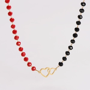 Detail of red and black faceted beads with a golden interlocking heart pendant necklace