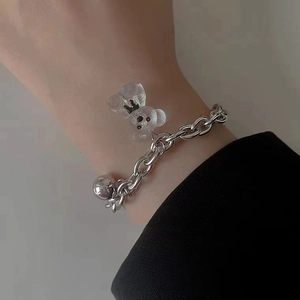 Detail of stainless steel magnetic couple bracelet featuring a cute transparent resin bear charm