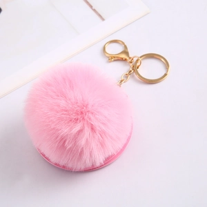 Detailed view of pink faux rabbit fur pompom keychain with golden metal ring hardware