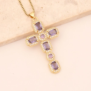 Detail of gold cross pendant with purple rectangular gemstones on a sleek box chain