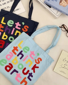 Detail of canvas tote bags with colorful chenille letter embroidery for daily commute