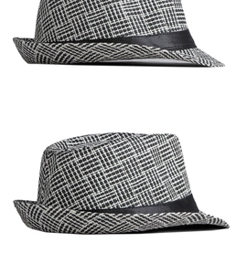 Close-up of black and white woven texture with black satin ribbon on a classic trilby hat