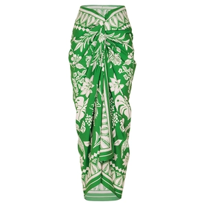 Detail of tropical green wrap skirt featuring white floral patterns and waist knot detail