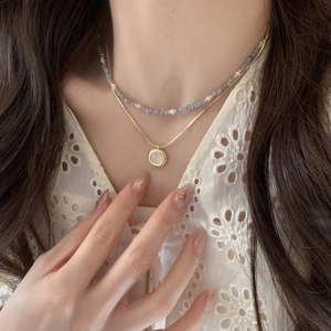 Double-layered gold chain necklace with blue beads and white opal pendant for women