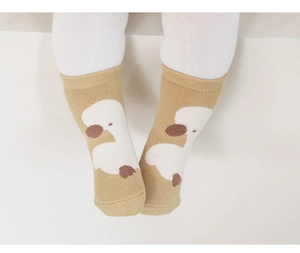 Detail showing non-slip baby walking socks with cute cartoon duck patterns on infant feet